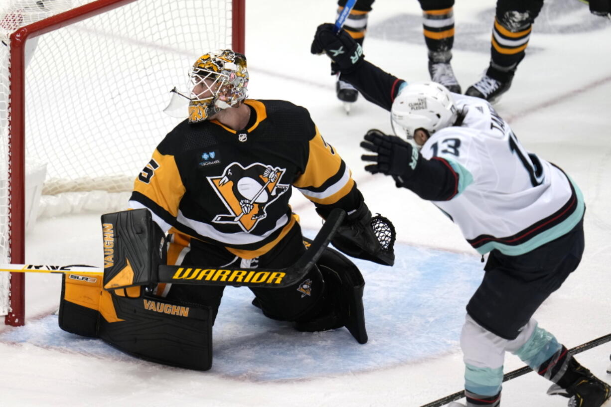 Seattle Kraken's Brandon Tanev (13) celebrates his goal after putting a shot behind Pittsburgh Penguins goaltender Tristan Jarry (35) during the third period of an NHL hockey game in Pittsburgh, Saturday, Nov. 5, 2022. The Kraken won 3-2.(AP Photo/{Gene J.