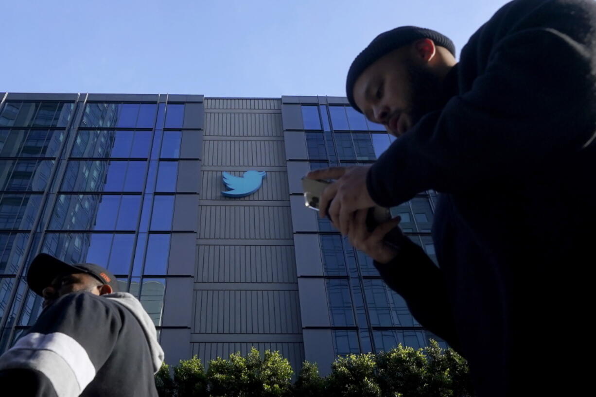 People walk outside Twitter headquarters in San Francisco, Friday, Nov. 4, 2022. Employees were bracing for widespread layoffs at Twitter on Friday, as new owner Elon Musk overhauls the social platform.