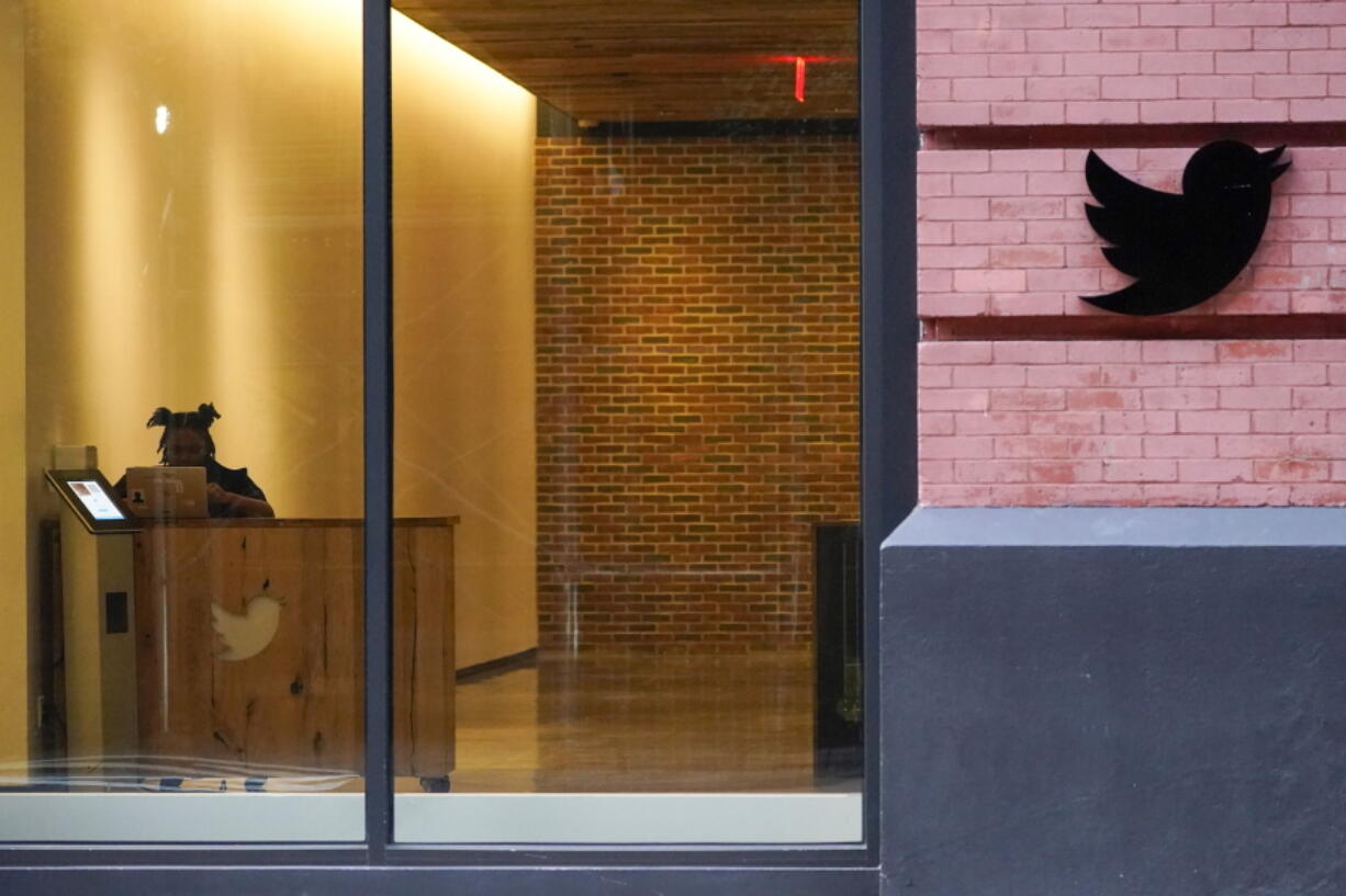 FILE - A receptionist works in the lobby of the building that houses the Twitter office in New York, Wednesday, Oct. 26, 2022. On Thursday, Nov. 17, 2022, Twitter continued to bleed engineers and other workers after new owner Elon Musk gave them a choice to pledge to "hardcore" work or resign with severance pay.