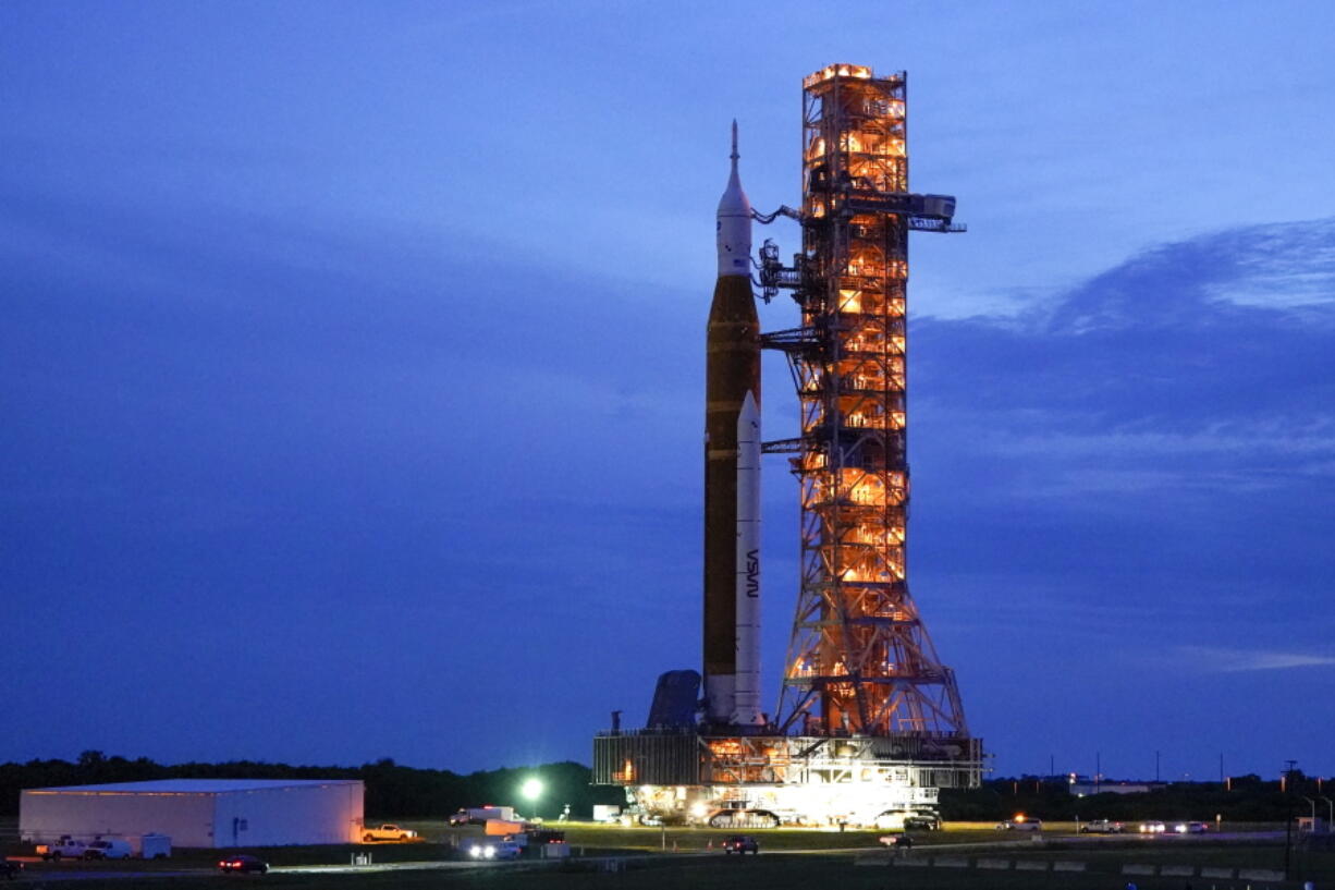 FILE - The NASA moon rocket slated for the Artemis mission to the moon rolls back to the Vehicle Assembly Building at the Kennedy Space Center Tuesday, Sept. 27, 2022, in Cape Canaveral, Fla. On Tuesday, Nov. 8, 2022, NASA announced it is again postponing the launch of its new moon rocket because of a storm threatening the Florida coast. NASA was aiming for a launch attempt this weekend -- just after midnight on Sunday.