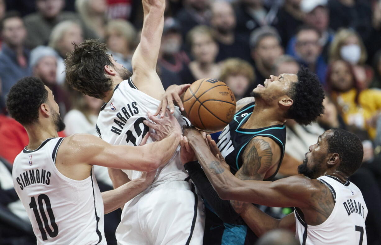 Portland Trail Blazers guard Anfernee Simons, second from right, is stopped by Brooklyn Nets forward Kevin Durant, right, forward Joe Harris, second from left, and guard Ben Simmons during the second half of an NBA basketball game in Portland, Ore., Thursday, Nov. 17, 2022.