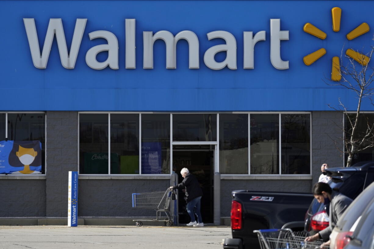 FILE - In this Nov. 5, 2020 file photo, a woman pushes a shopping cart to enter a Walmart in Rolling Meadows, Ill.  Walmart on Tuesday, Nov. 15, 2022 become the latest major player in the drug industry to announce a plan to settle lawsuits filed by state and local governments over the toll of powerful prescription opioids sold at its pharmacies with state and local governments across the U.S. (AP Photo/Nam Y.