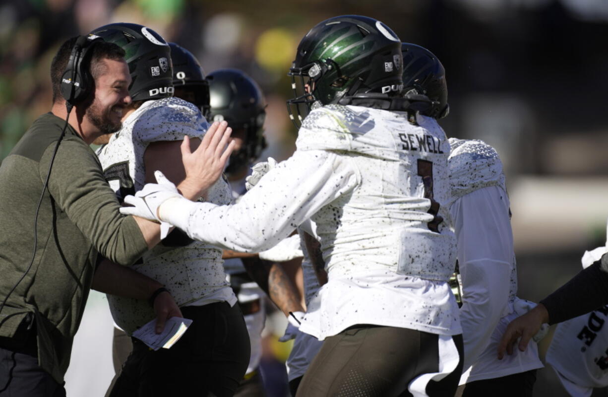 Oregon head coach Dan Lanning, left, congratulates Noah Sewell after he rushed for a 1-yard touchdown against Colorado in the first half of an NCAA college football game, Saturday, Nov. 5, 2022, in Boulder, Colo.