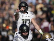 Oregon quarterback Bo Nix directs players at the line of scrimmage against Colorado in the first half of an NCAA college football game, Saturday, Nov. 5, 2022, in Boulder, Colo.