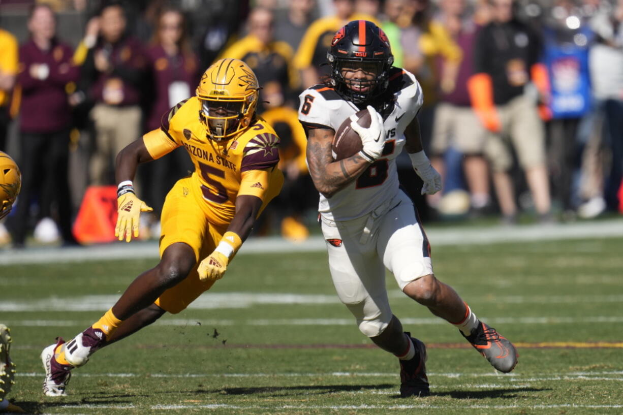 Oregon State running back Damien Martinez (6) runs past Arizona State defensive back Chris Edmonds (5) during the first half of an NCAA college football game in Tempe, Ariz., Saturday, Nov. 19, 2022. (AP Photo/Ross D.