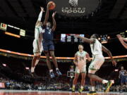 Connecticut guard Tristen Newton (2) shoots between Oregon guard Rivaldo Soares, left, guard Brady Parris (24) and center N'Faly Dante during the second half of an NCAA college basketball game in the Phil Knight Invitational tournament in Portland, Ore., Thursday, Nov. 24, 2022.