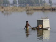 Villagers retrieve belongings while they wade through a flooded area, in Qambar Shahdadkot, in Sindh province, Pakistan.