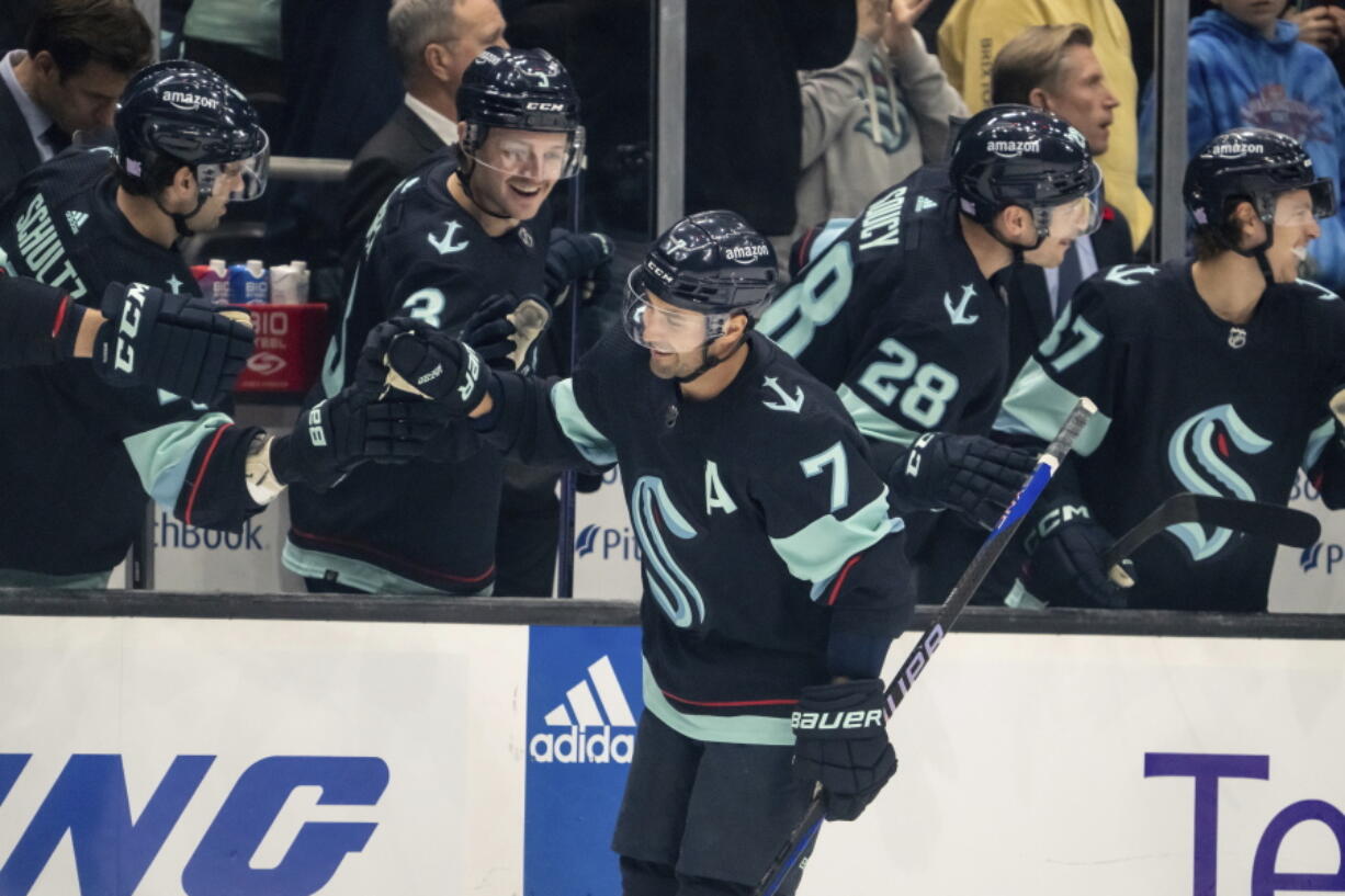 Seattle Kraken forward Jordan Eberle is congratulated by teammates on the bench after scoring a goal against the Nashville Predators during the first period of an NHL hockey game, Tuesday, Nov. 8, 2022, in Seattle.