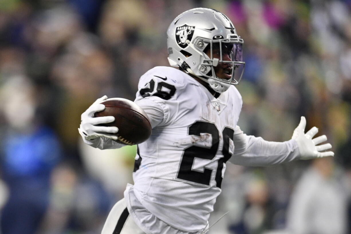 Las Vegas Raiders running back Josh Jacobs (28) celebrates as he scores the game-winning touchdown during overtime of an NFL football game against the Seattle Seahawks Sunday, Nov. 27, 2022, in Seattle.