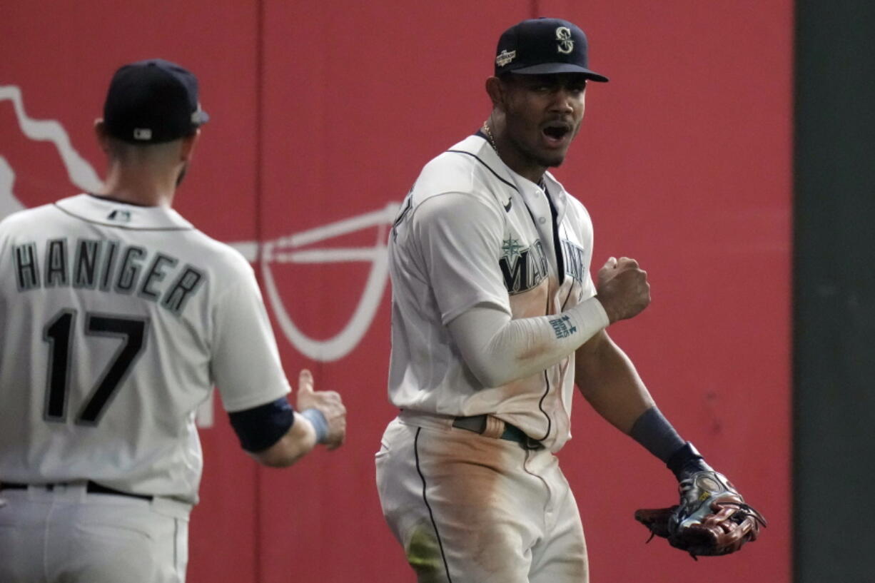 FILE - Seattle Mariners center fielder Julio Rodriguez, right, celebrates after making a catch for an out against the Houston Astros, during the 16 inning in Game 3 of an American League Division Series baseball game Saturday, Oct. 15, 2022, in Seattle. Rodr?guez and Atlanta's Michael Harris II, a pair of 21-year-old center fielders, are baseball's Rookies of the Year.