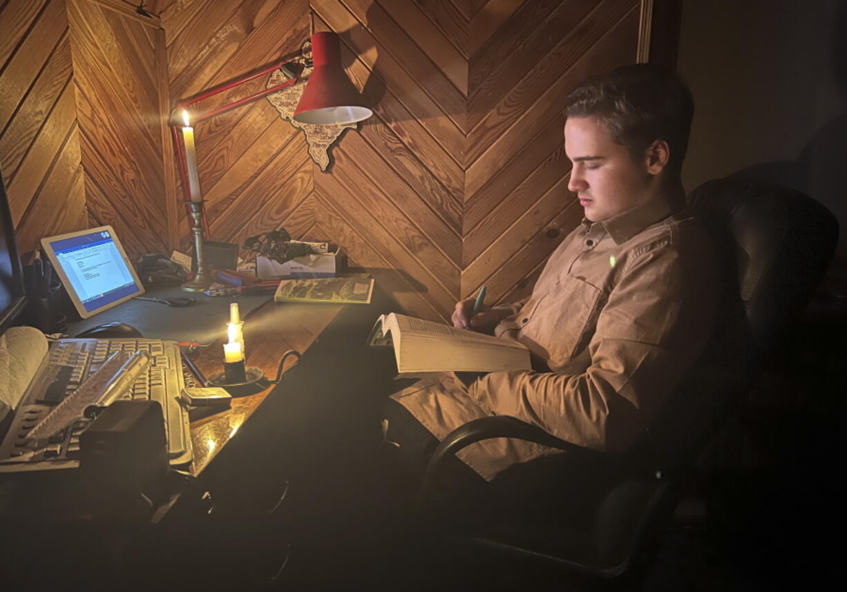 Danylo, 17 has an online biology lesson by candlelight in the village of Start Petrivtsi close to Kyiv, Ukraine, Thursday, Nov. 3, 2022. Rolling blackouts because of Russia's rocket attacks are increasing across Ukraine as the government rushes to stabilize the energy grid and repair the system ahead of winter.