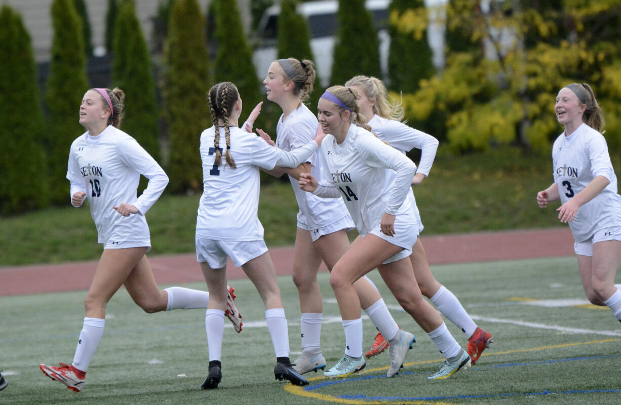 Seton Catholic's Hailey Herboth (center) is congratulated by her teammates after scoring a goal in a 4-1 win over La Center during the 1A girls soccer district third-place match at King's Way Christian High School on Saturday, Nov. 5, 2022.