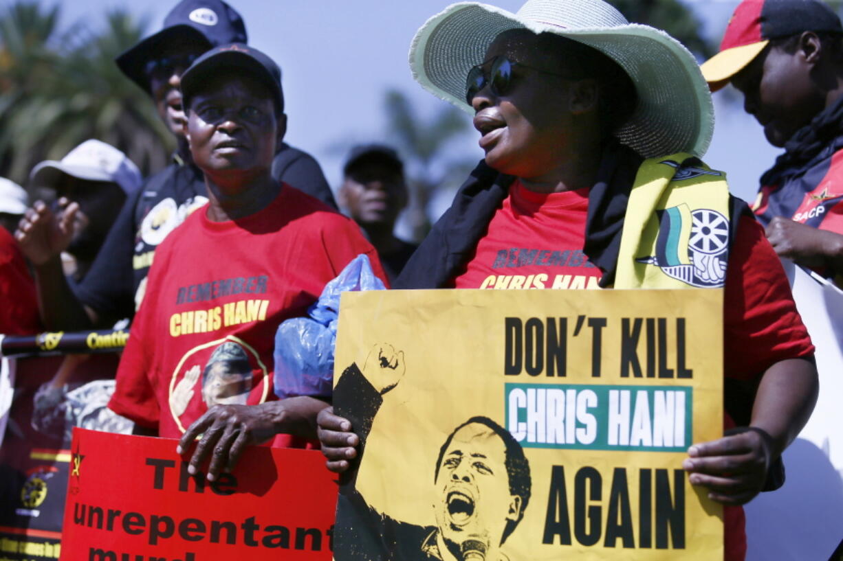 Demonstrators stage a protest against the release on parole of Janusz Walus, convicted killer of South African anti-apartheid leader Chris Hani, seen in an April 1993 image on the poster, in Pretoria, South Africa, Wednesday, Nov. 30, 2022. Walus was stabbed in prison, two days before he was due to be released on parole, prison authorities said Tuesday.