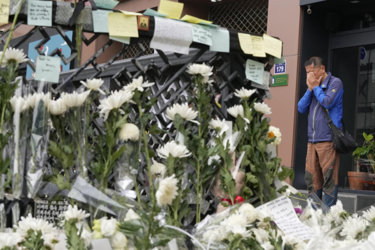 A man weeps as he pays tribute to victims of a deadly accident following Saturday night's Halloween festivities on a street near the scene in Seoul, South Korea, Tuesday, Nov. 1, 2022.  South Korean police investigated on Monday what caused a crowd surge that killed more than 150 people during Halloween festivities in Seoul in the country's worst disaster in years.