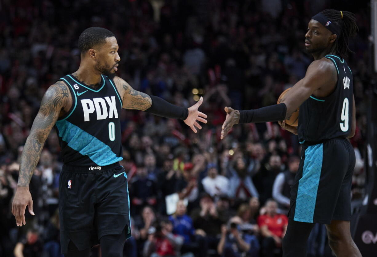 Portland Trail Blazers guard Damian Lillard, left, and forward Jerami Grant celebrate at the end of the team's NBA basketball game against the San Antonio Spurs in Portland, Ore., Tuesday, Nov. 15, 2022.