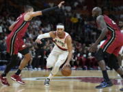 Portland Trail Blazers guard Josh Hart (11) drives to the basket against Miami Heat forward Caleb Martin, left, and center Dewayne Dedmon, right, during the first half of an NBA basketball game, Monday, Nov. 7, 2022, in Miami.