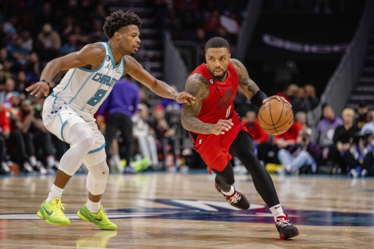 Charlotte Hornets guard Dennis Smith Jr. (8) guards Portland Trail Blazers guard Damian Lillard (0) during the second half of an NBA basketball game Wednesday, Nov. 9, 2022, in Charlotte, N.C.