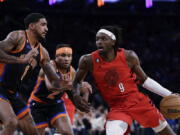 Portland Trail Blazers forward Jerami Grant (9) drives against New York Knicks forward Obi Toppin during the first half of an NBA basketball game Friday, Nov. 25, 2022, in New York.