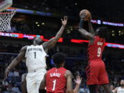 New Orleans Pelicans forward Zion Williamson (1) reaches for a rebound held by Portland Trail Blazers forward Jerami Grant (9) during the first half of an NBA basketball game in New Orleans, Thursday, Nov. 10, 2022.