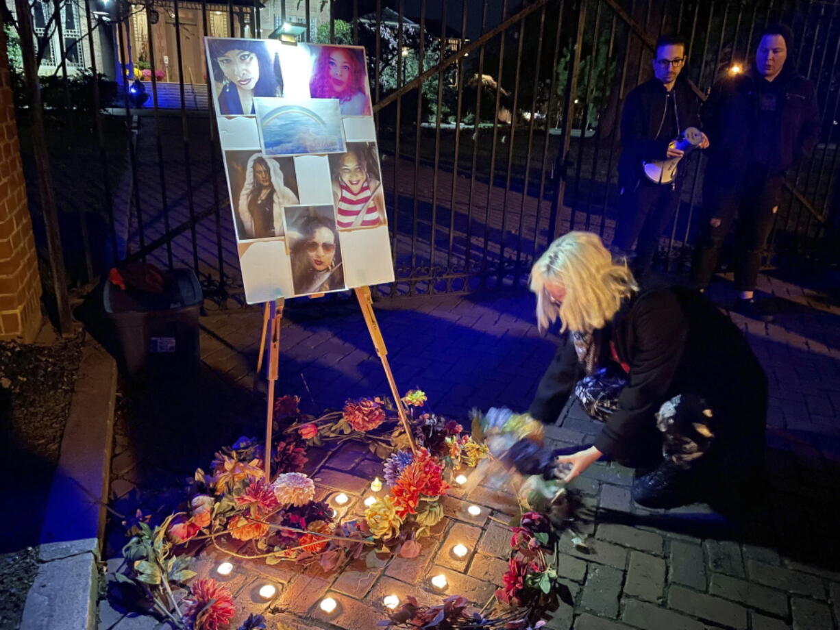 A resident places a flower on a memorial for Sasha Mason, a 45-year-old transgender woman killed in Zebulon, N.C., at a Transgender Day of Remembrance vigil in Raleigh, N.C., Sunday, Nov. 20, 2022.