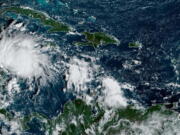 This satellite image taken at 8:40am ET and provided by NOAA shows Tropical Storm Lisa under Cuba in the Caribbean Sea, Tuesday, Nov. 1, 2022. Lisa is forecast to make landfall in Central America later in the week as a likely hurricane.