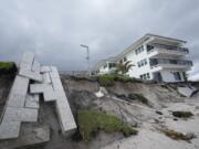 Condominium amenities and a unit terrace lie toppled onto the beach after the sand below was swept away, following the passage of Hurricane Nicole, Thursday, Nov. 10, 2022, at Ocean Club Condominiums in Vero Beach, Fla.