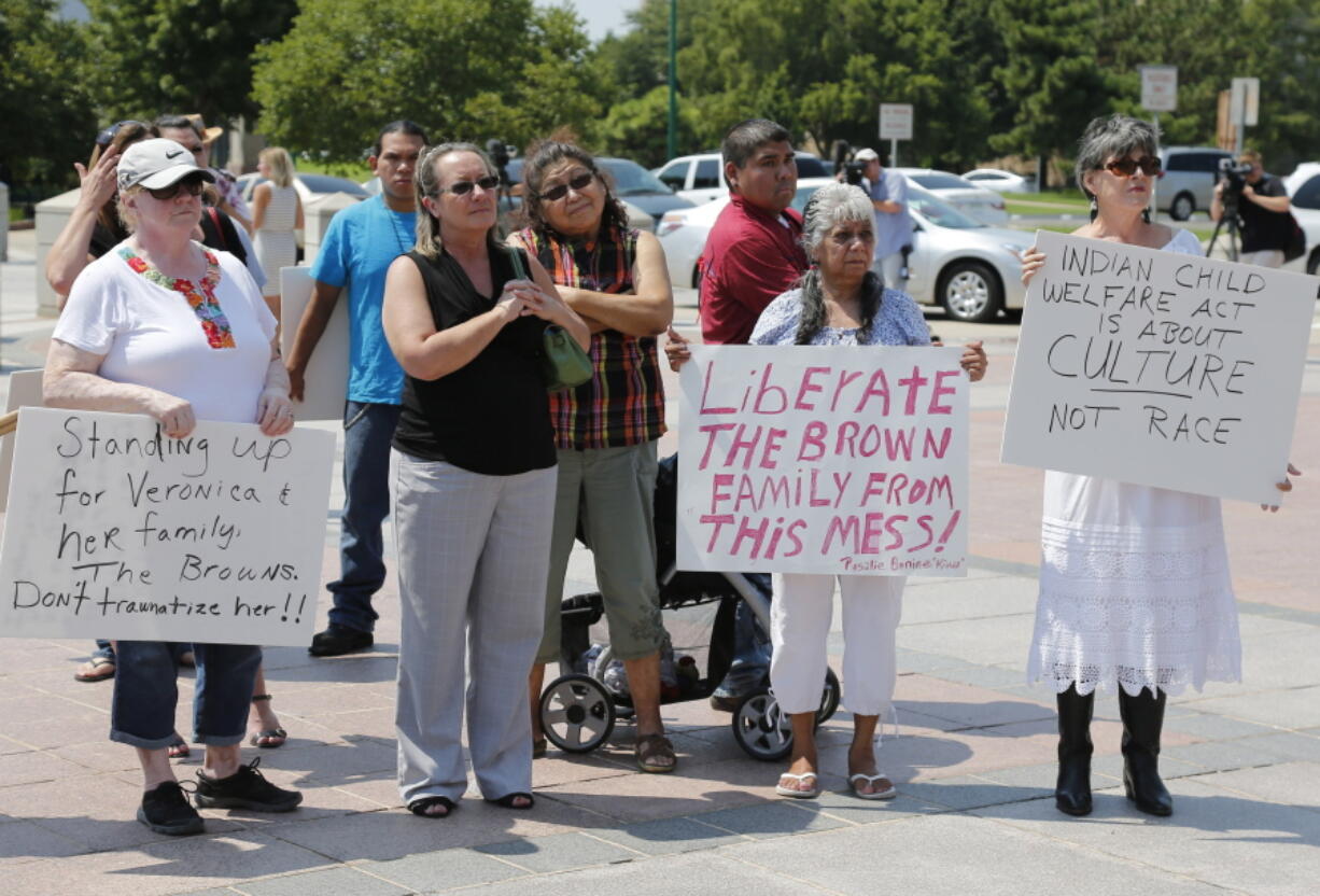 FILE - Participants listen during a rally in support of three-year-old baby Veronica, Veronica's biological father, Dusten Brown, and the Indian Child Welfare Act, in Oklahoma City, Monday, Aug. 19, 2013. Brown is trying to maintain custody of the girl who was given up for adoption by her birth mother to Matt and Melanie Capobianco of South Carolina. The U.S. Supreme Court will hear arguments, Wednesday, Nov. 9, 2022 on the most significant challenge to the Indian Child Welfare Act that gives preference to Native American families in foster care and adoption proceedings of Native American children since it passed in 1978.