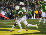 Oregon wide receiver Troy Franklin (11) hauls in a touchdown pass in front of Utah cornerback Clark Phillips III (1) during the first half of an NCAA college football game Saturday, Nov. 19, 2022, in Eugene, Ore.