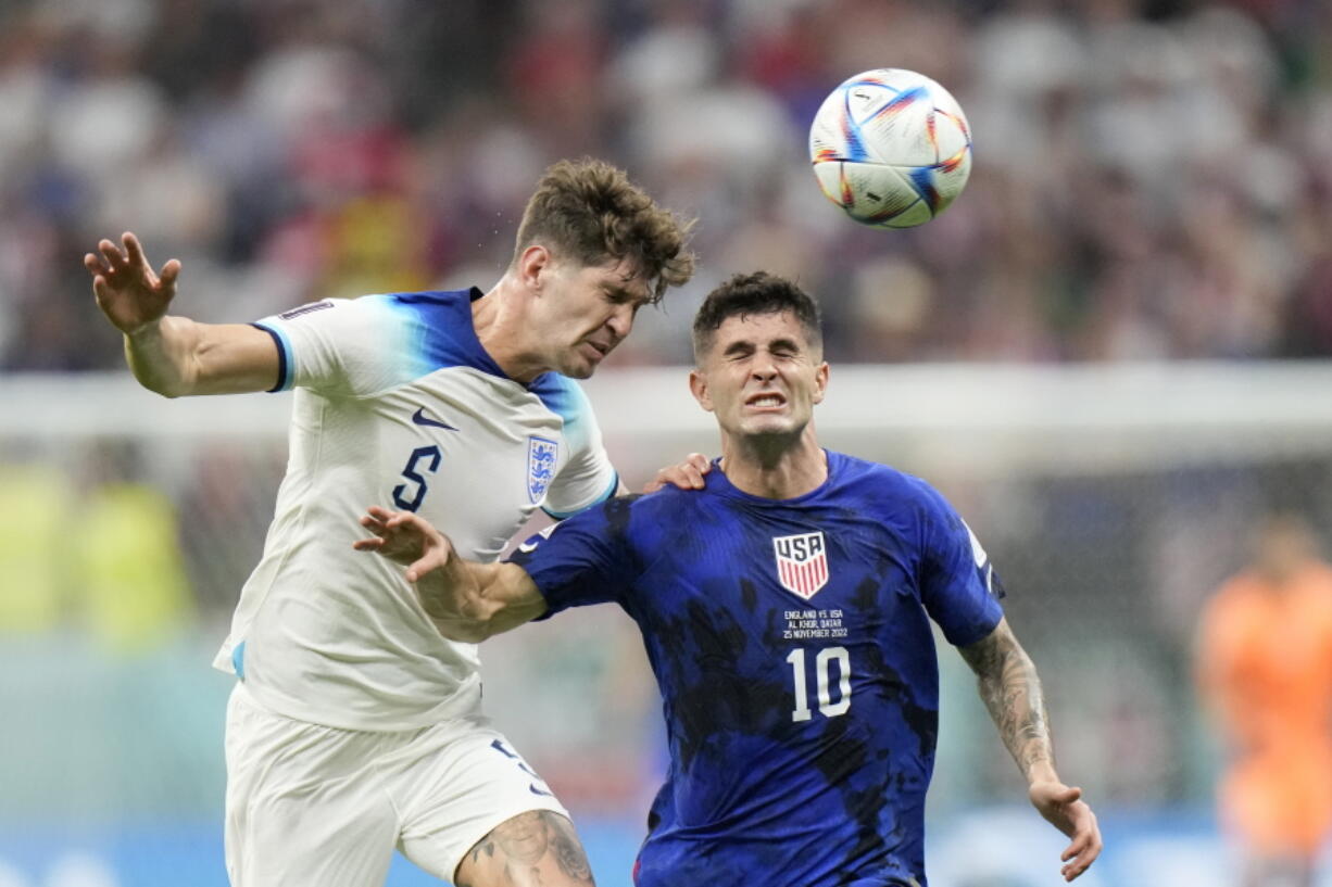 England's John Stones vies for the ball with Christian Pulisic of the United States, right, during the World Cup group B soccer match between England and The United States, at the Al Bayt Stadium in Al Khor , Qatar, Friday, Nov. 25, 2022.