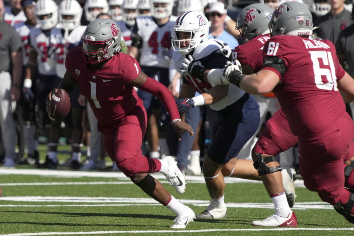 Washington State quarterback Cameron Ward (1) runs away from pressure in the first half during an NCAA college football game against Arizona, Saturday, Nov. 19, 2022, in Tucson, Ariz.