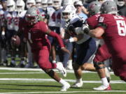 Washington State quarterback Cameron Ward (1) runs away from pressure in the first half during an NCAA college football game against Arizona, Saturday, Nov. 19, 2022, in Tucson, Ariz.