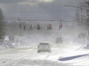 Cars drive through blowing, drifting snow on McKinley Parkway in Hamburg in Erie County, N.Y., Sunday, Nov. 20, 2022.