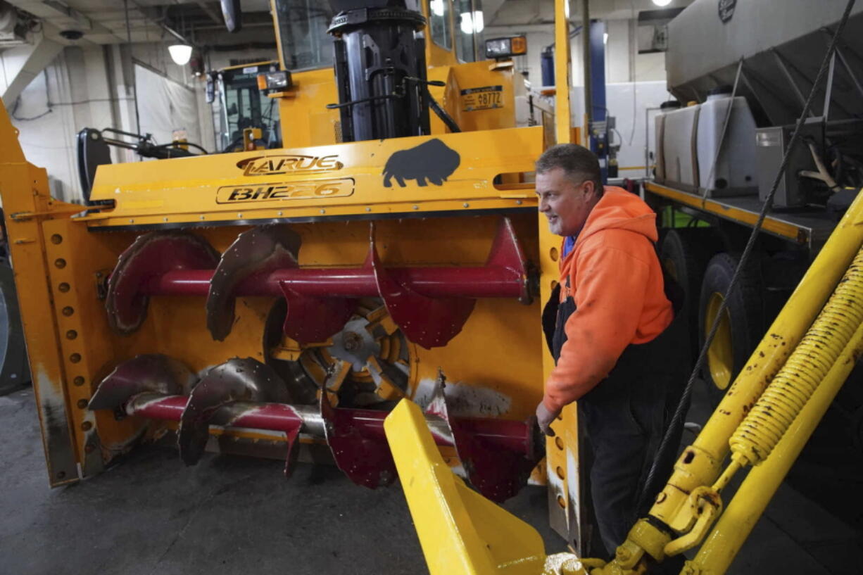 Heavy equipment operator Don Beitz walks around a giant snow thrower while preparing for the impending snowstorm that is expected to dump several feet of snow on the area Thursday at the New York State Thruway's Walden Garage in Cheektowaga, N.Y.