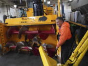 Heavy equipment operator Don Beitz walks around a giant snow thrower while preparing for the impending snowstorm that is expected to dump several feet of snow on the area Thursday at the New York State Thruway's Walden Garage in Cheektowaga, N.Y.