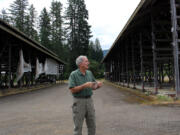 Skamania County Commissioner Bob Hamlin stands in front of derelict buildings as he talks about future development plans.