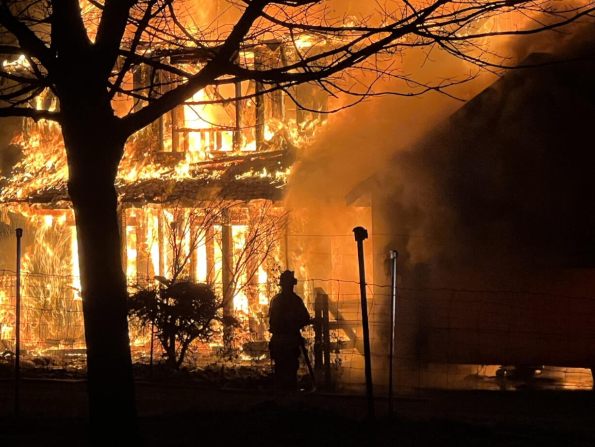 Clark-Cowlitz Fire Rescue firefighters extinguish a house fire Dec. 13, 2022, northeast of La Center that displaced a family of five.