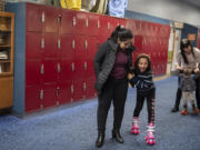 Maryam Azizpour offers support for her daughter, Murwarid Azizpour, as she navigates the locker area at Oaks Park Roller Rink in Portland on Nov. 20.