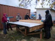 Future homeowner Stephanie Sutton-Davis, left in red, works with construction coordinator Jess Reynolds, in blue, as crews from Habitat for Humanity lend a hand to the housing project Nov. 2. Construction has begun on Evergreen Habitat for Humanity's Johnson Village, a subdivision in east Vancouver that will house nine low-income families.