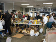 A diverse cast of volunteers, from high school students to retired folk, sort through nonperishable food and goods donated by local residents for the annual Walk & Knock campaign in Vancouver on Saturday.