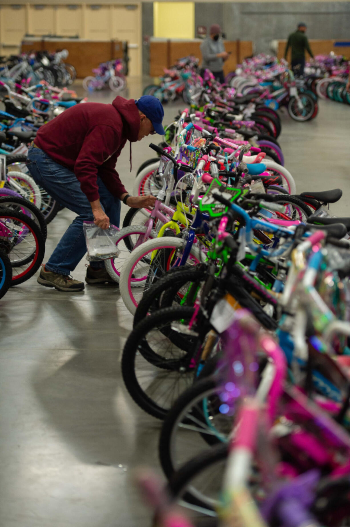 Pat Cotter of Vancouver, a Bike Clark County club member, puts the finishing touches on bicycles ready to go out Saturday during Waste Connections' Scott Campbell Christmas Promise.