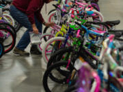 Pat Cotter of Vancouver, a Bike Clark County club member, puts the finishing touches on bicycles ready to go out Saturday during Waste Connections' Scott Campbell Christmas Promise.