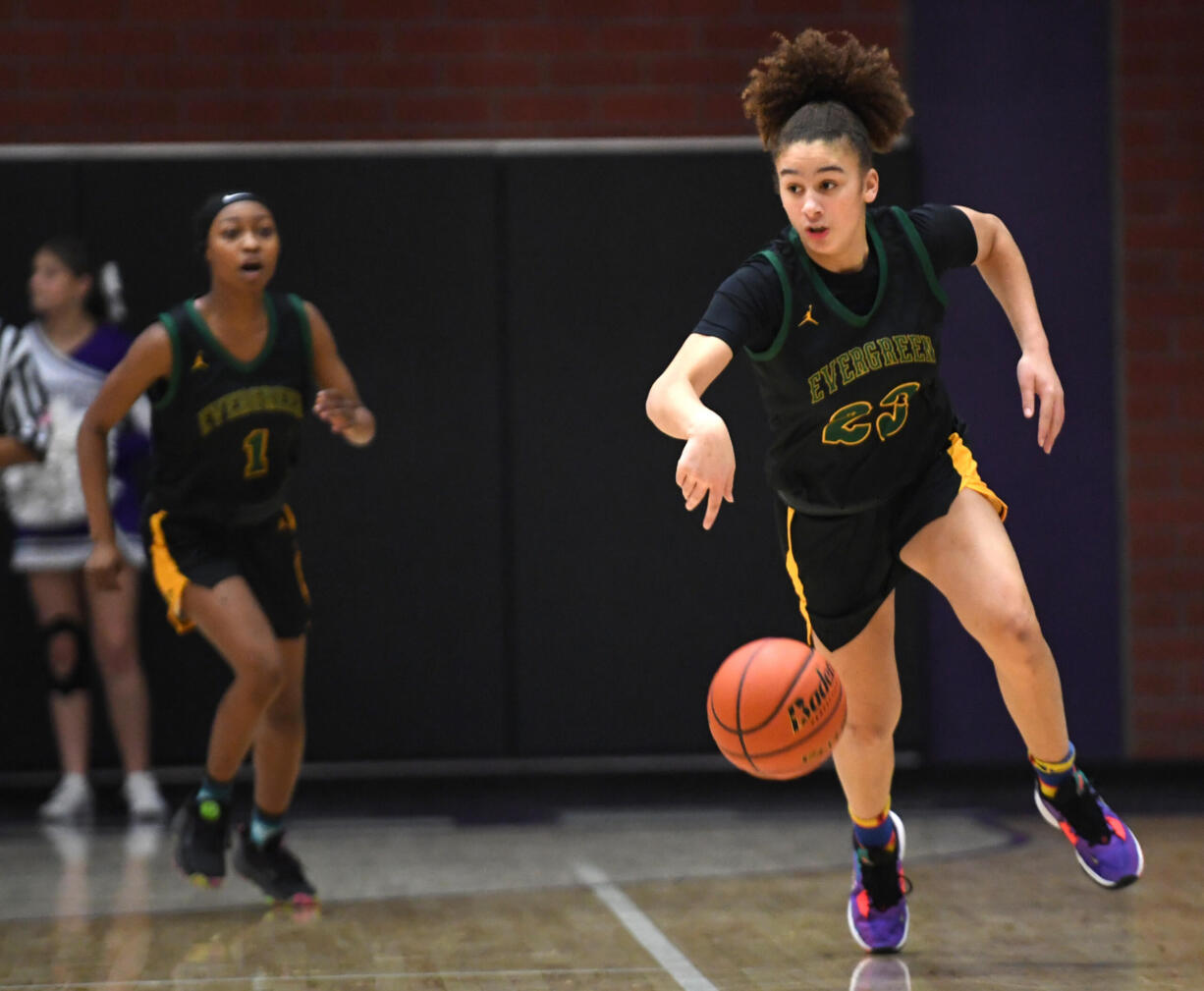 Evergreen sophomore Adrian Wright, right, dribbles down the court Friday, Dec. 9, 2022, during the Plainsmens’ 64-55 win against Heritage at Heritage High School.