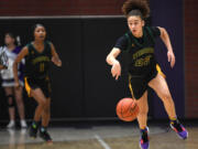 Evergreen sophomore Adrian Wright, right, dribbles down the court Friday, Dec. 9, 2022, during the Plainsmens’ 64-55 win against Heritage at Heritage High School.