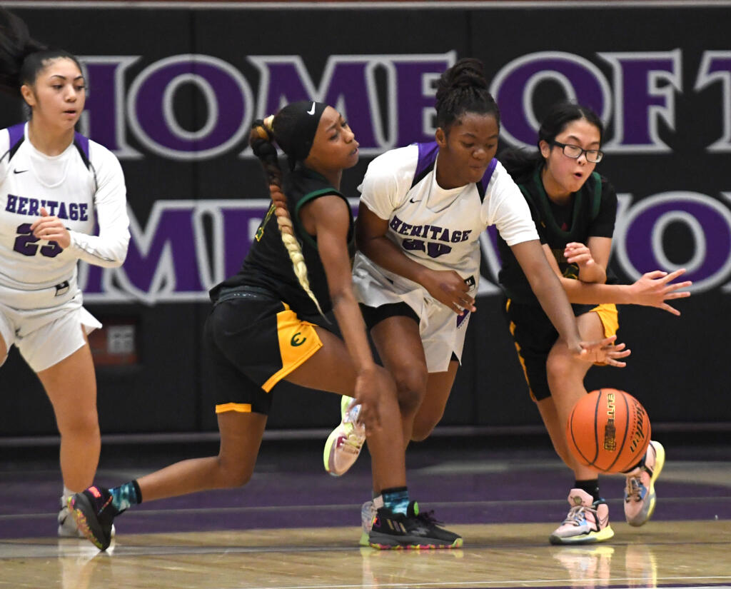 Heritage freshman Jaila Ellis, center, splits two Evergreen defenders Friday, Dec. 9, 2022, during the T-Wolves’ 64-55 loss to Evergreen at Heritage High School.