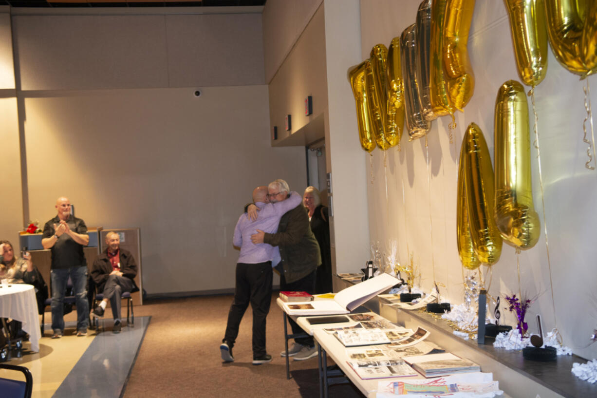 Al Aldridge hugs event organizer Eric Sawyer at a celebration of Aldridge's more than three decades as a music teacher at Battle Ground and Prairie high schools. The surprise party was held Sunday at Clark College's Gaiser Hall.