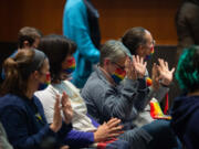 Unable to applaud due to meeting rules, supporters of Drag Queen Story Hour wave their hands in support of points speakers are making.