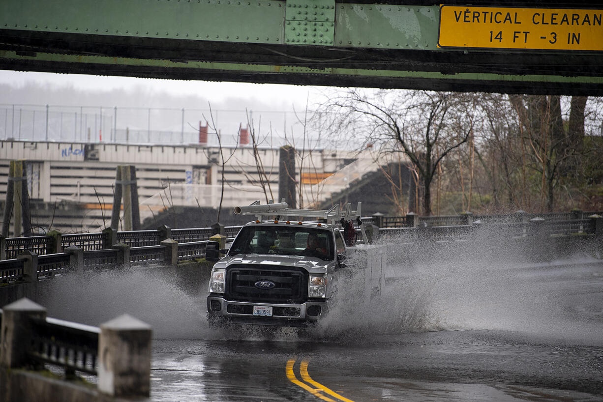 A motorist navigates a pool of standing water underneath the Interstate Bridge on Tuesday morning, Dec. 27, 2022.