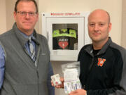 Washougal School District assistant superintendent Aaron Hansen, left, and Washougal High School principal Mark Castle display a dose of Narcan, a medication used to assist people who have experienced an overdose of opioids. The Washougal School Board recently approved a policy that states that Narcan will be placed in every one of the district's schools.