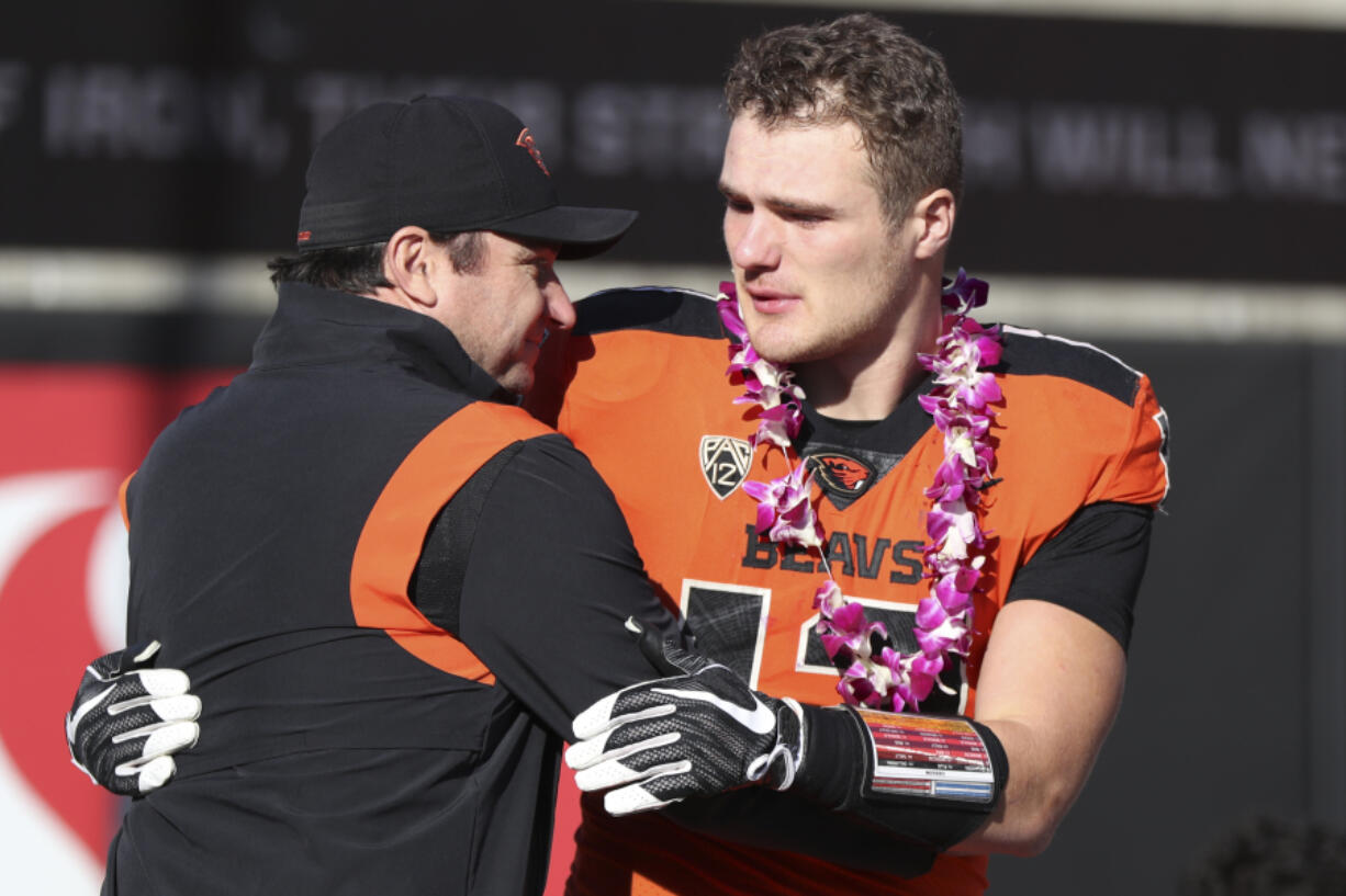 Oregon State head coach Jonathan Smith hugs linebacker Jack Colletto (12) during a Senior Day ceremony prior to an NCAA college football game against Oregon on Saturday, Nov 26, 2022, in Corvallis, Ore. Oregon State won 38-34.