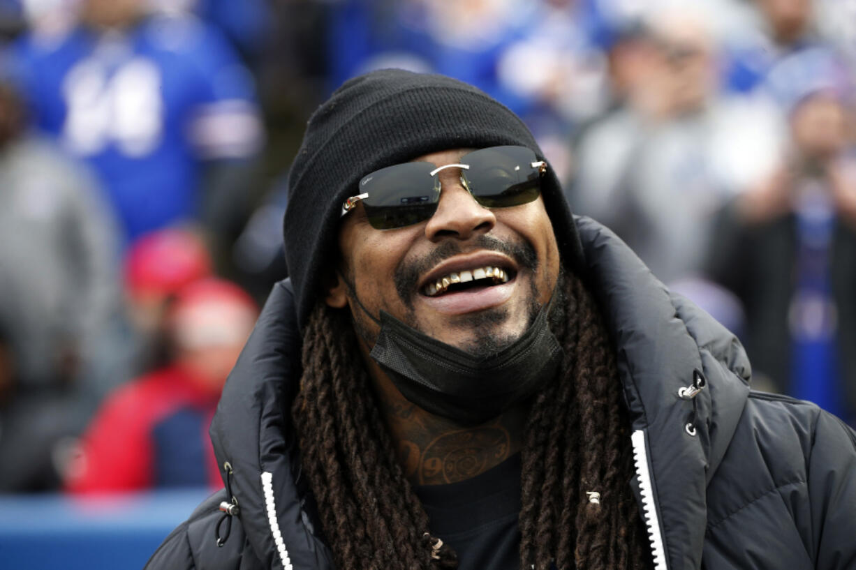 Marshawn Lynch stands on the field before an NFL football game between the Buffalo Bills and the Indianapolis Colts in Orchard Park, N.Y., Nov. 21, 2021.